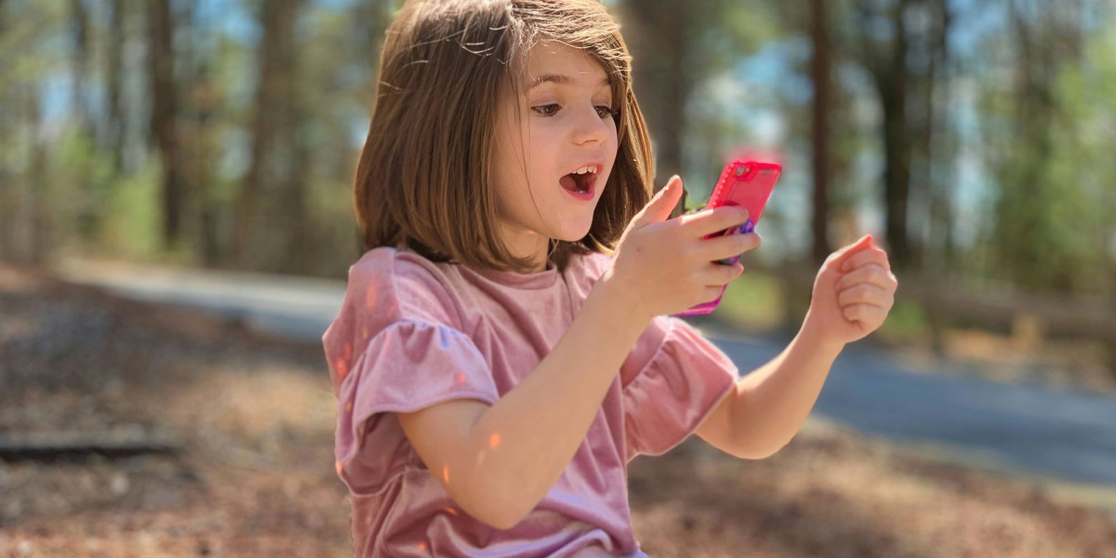Apple continues to roll out age verification around the world | A young girl using a smartphone