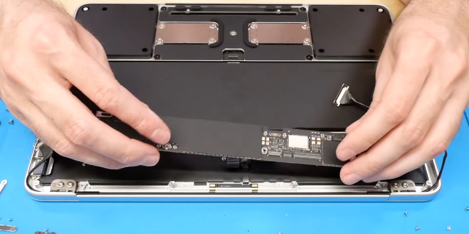 DIY MacBook Neo upgrade can boost the SSD to 1TB using iPhone parts | Photo shows the old SSD being removed