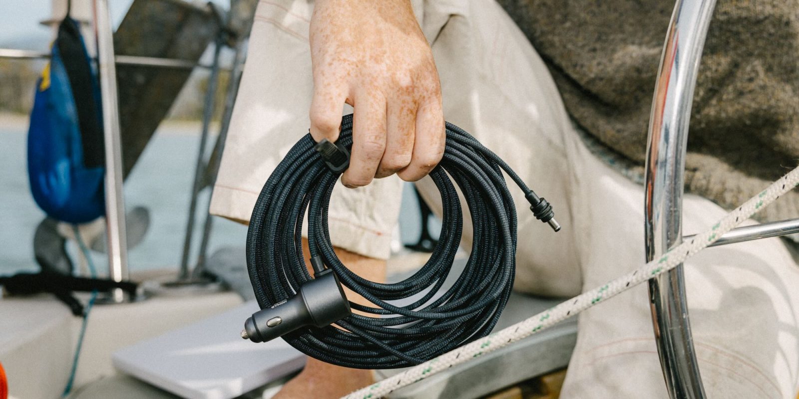 A hand holding a black cable
