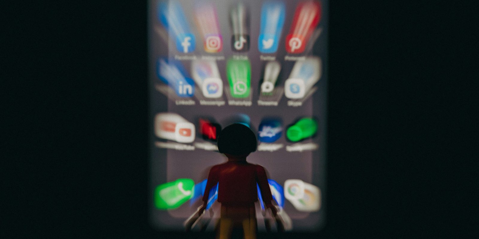 60% of TikTok videos are AI slop; 21% of YouTube ones | Image shows a toy robot character in front of a blurred set of app icons
