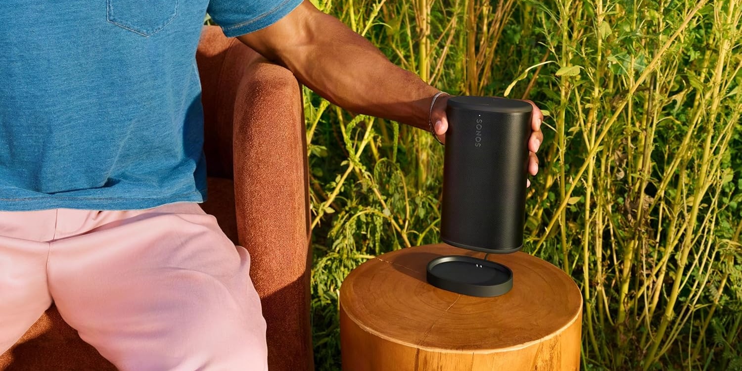 A person holding a black speaker