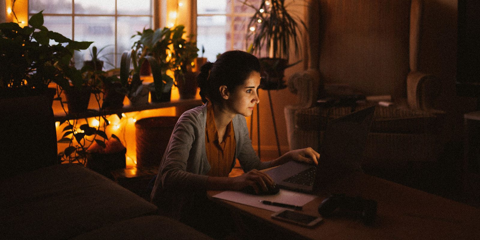 Claude AI will ask you whether you're using it too much | Photo shows a woman using a laptop in a darkened room