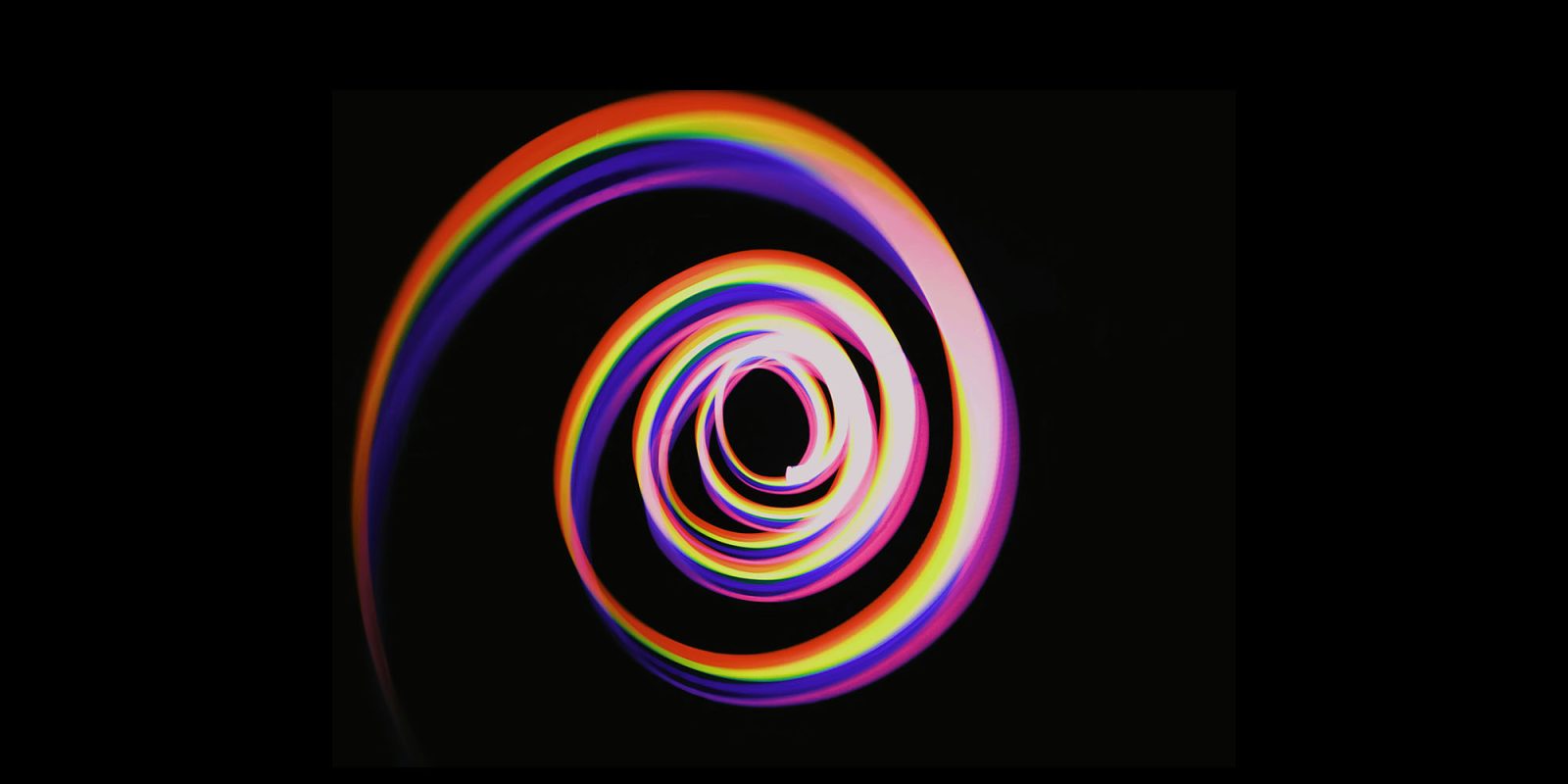 Here's how to avoid being trapped in never-ending Apple Upgrade leases | Image shows a colourful spiral against a black background