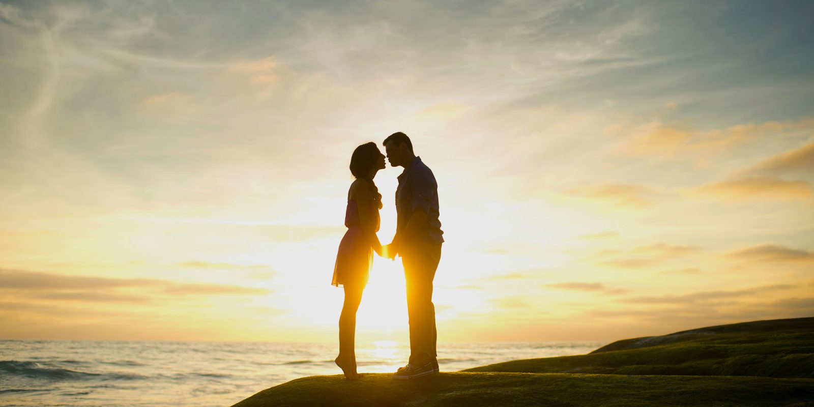 The iPhone contributed to 'a collapse in US fertility,' claims scientific study | Photo shows a couple kissing on a coastline, silhouetted against a sunset