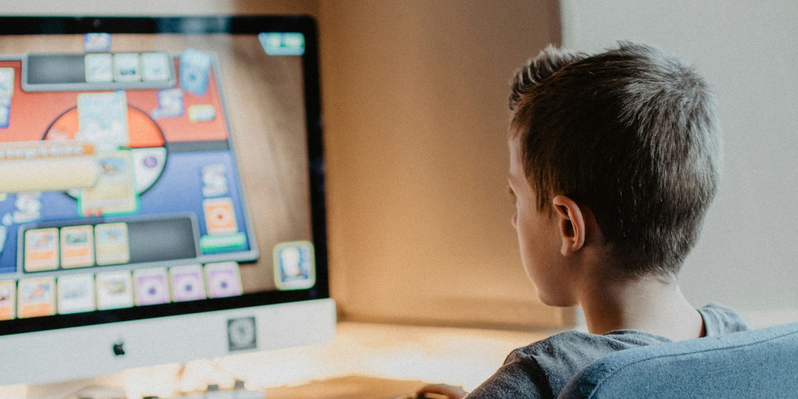 Parents urged to change screen time limits as kids head back to school | Photo shows a young boy playing a game on an iMac