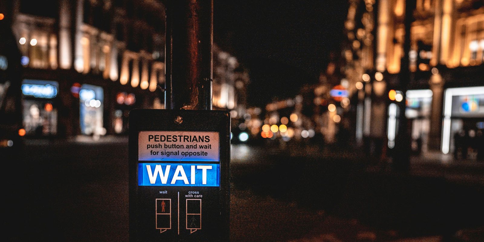 Prepare to wait for Siri AI access when iOS 27 launches next month | Photo shows a pedestrian crossing signal with the word Wait displayed
